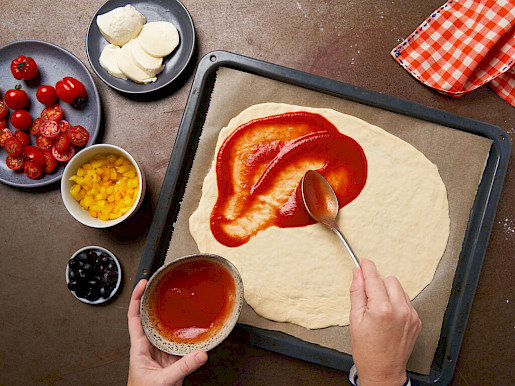 Schritt 6: Pizzateig mit Tomatensoße einstreichen